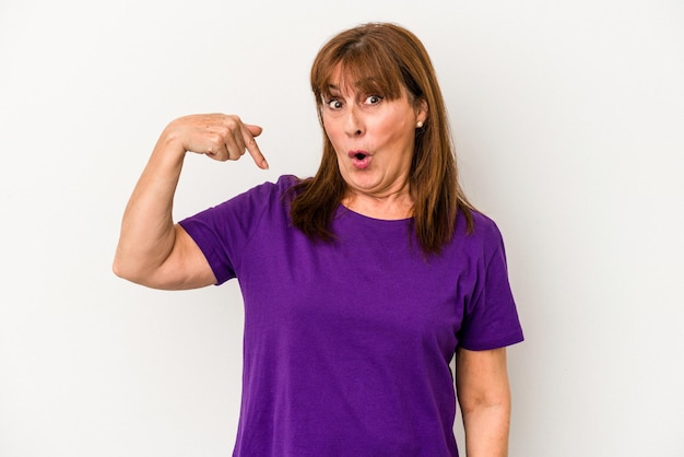 Middle age caucasian woman isolated on white background person pointing by hand to a shirt copy space, proud and confident