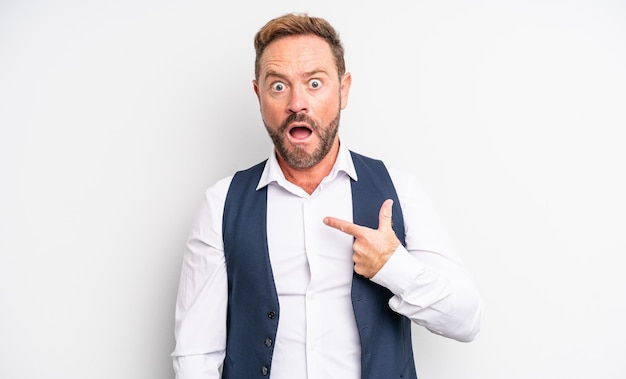 Middle age handsome man looking shocked and surprised with mouth wide open, pointing to self