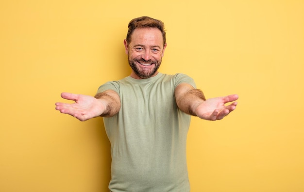 Photo middle age handsome man smiling cheerfully giving a warm, friendly, loving welcome hug, feeling happy and adorable