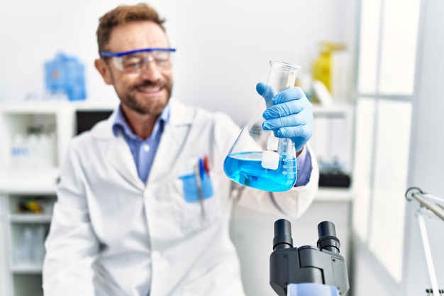 Middle age hispanic man wearing scientist uniform working at laboratory