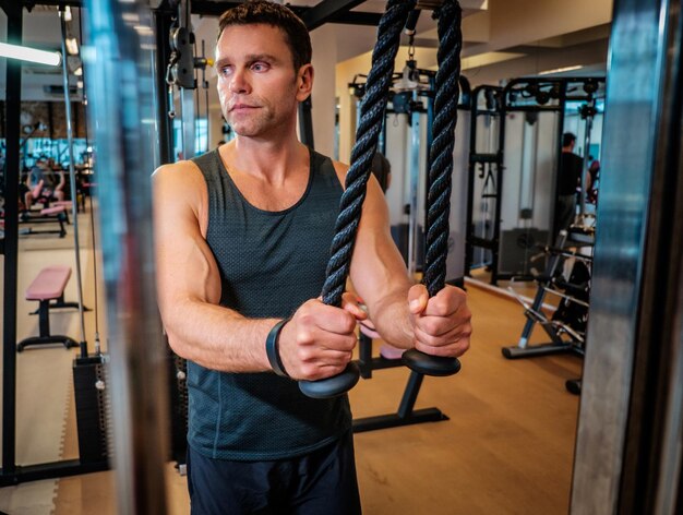 Middle age man doing workout in a gym club.