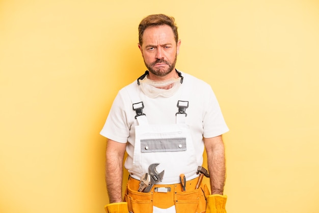 Photo middle age man feeling sad and whiney with an unhappy look and crying handyman and repair concept