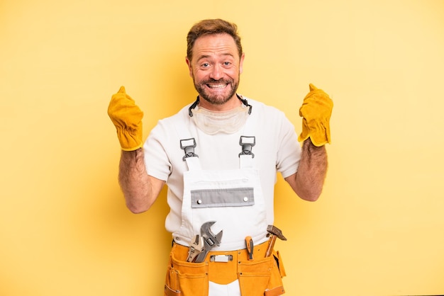 Middle age man feeling shockedlaughing and celebrating success handyman and repair concept