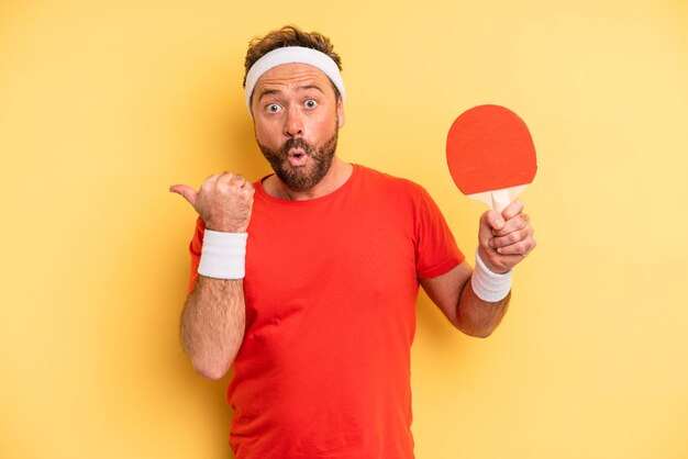 Photo middle age man looking astonished in disbelief ping pong concept