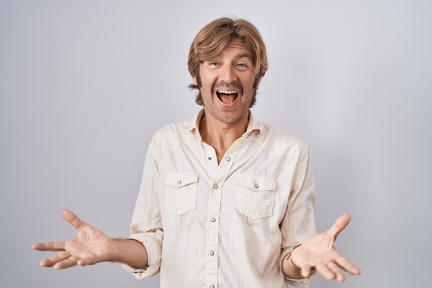 Middle age man standing over isolated background smiling cheerful with open arms as friendly welcome, positive and confident greetings