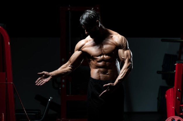 Middle Age Man Standing Strong In The Gym And Flexing Muscles - Muscular Athletic Bodybuilder Fitness Model Posing After Exercises