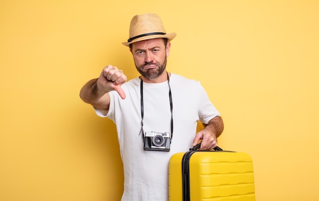 Middle age man tourist feeling cross,showing thumbs down. travel concept