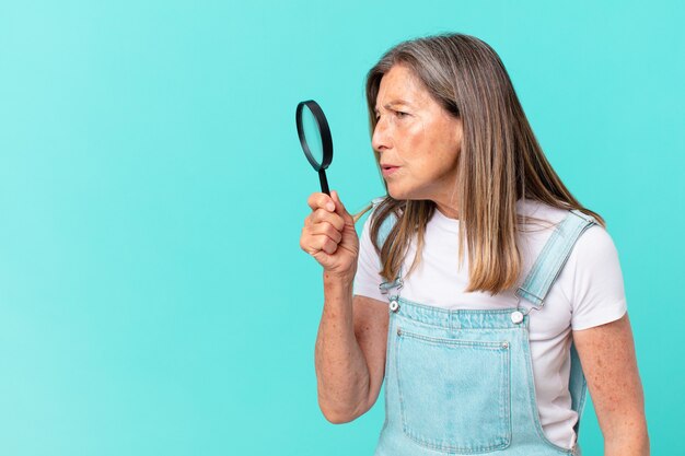 Middle age pretty woman with a magnifying glass. search concept