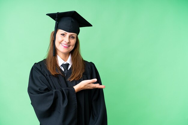 Middle age university graduate woman over isolated background presenting an idea while looking smiling towards