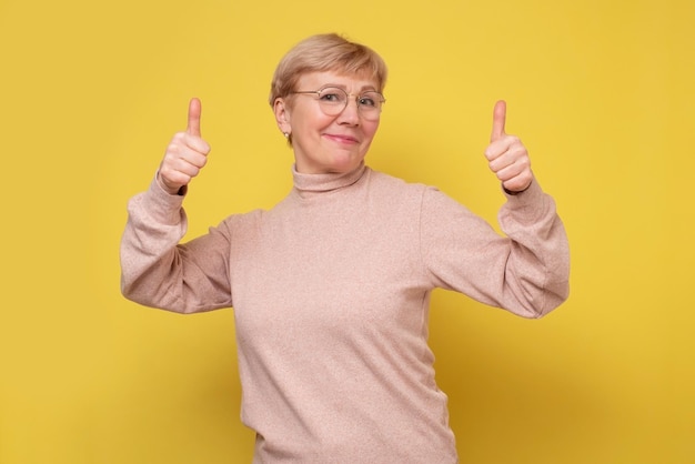 Middle age woman approving showing positive gesture with hand thumbs up