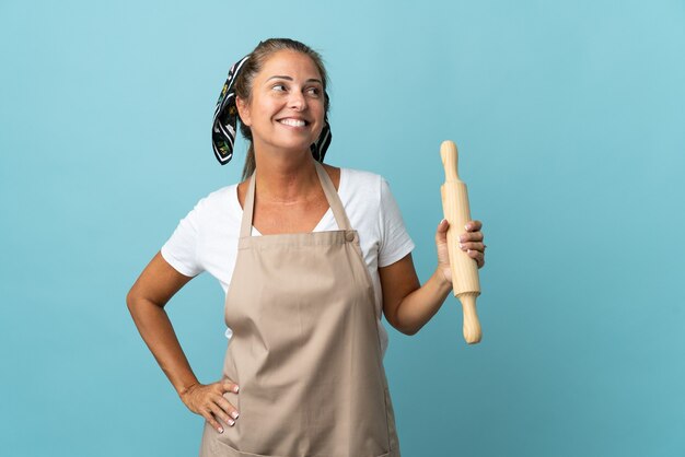 Middle age woman in chef uniform looking to the side and smiling