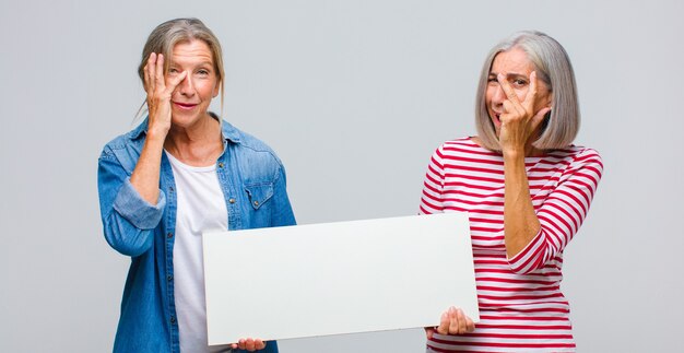 Middle age woman feeling bored, frustrated and sleepy after a tiresome, dull and tedious task, holding face with hand