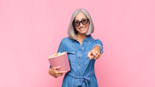 Middle age woman pointing at camera with a satisfied, confident