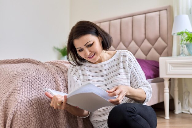 Middle age woman relaxing at home reading a book