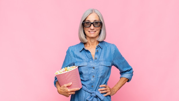 Middle age woman smiling happily with a hand on hip and confident isolated