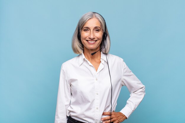 Middle age woman smiling happily with a hand on hip and confident