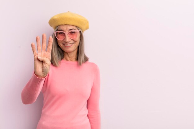 Middle age woman smiling and looking friendly showing number four