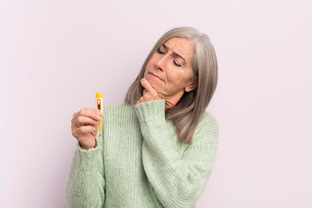 Middle age woman thinking feeling doubtful and confused medicine thermometer concept