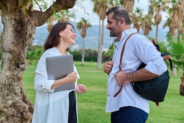 Middle aged business colleagues talking in the park