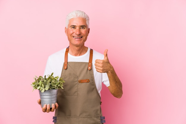 Middle aged gardener man isolated smiling and raising thumb up