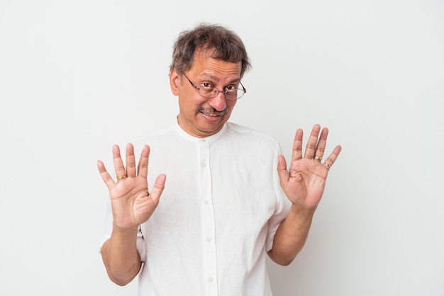 Middle aged indian man isolated on white background rejecting someone showing a gesture of disgust.