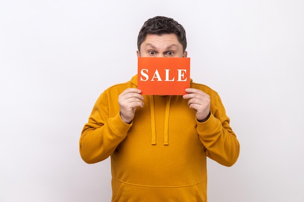 Middle aged man covering half of face with Sale inscription market discounts black friday