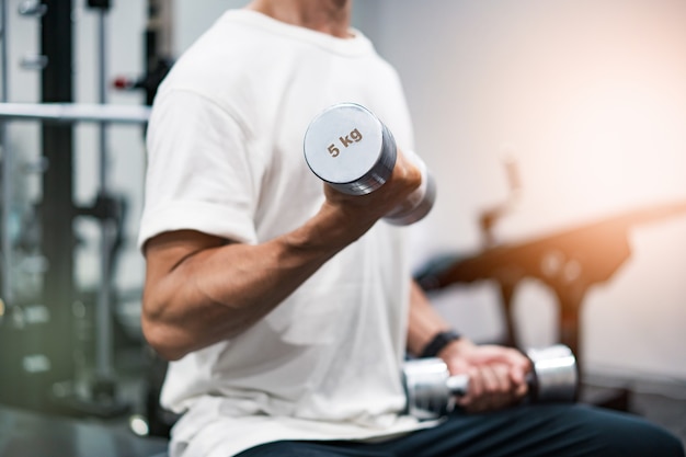 MIddle-aged man doing muscle training with dumbbells