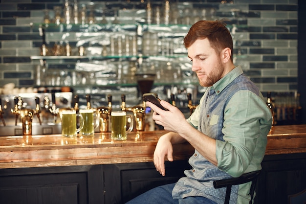 Middle-aged man. Guy with a phone at bar. Man in a denim shirt in a cell.