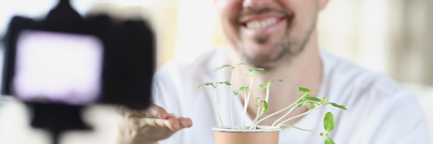 Middle aged man recording on video how he growing plants at home