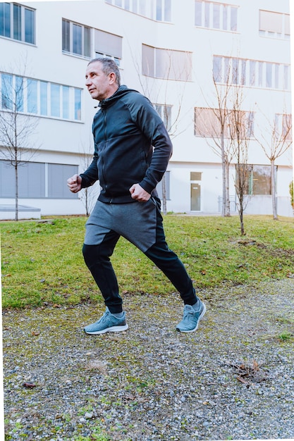 Middle-aged man in tracksuit doing jog in morning