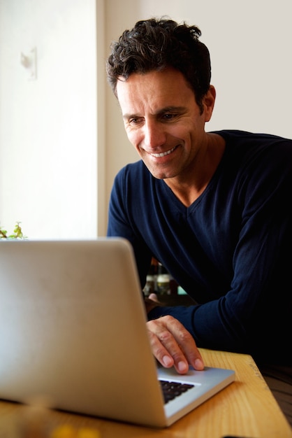 Middle aged man using laptop at home