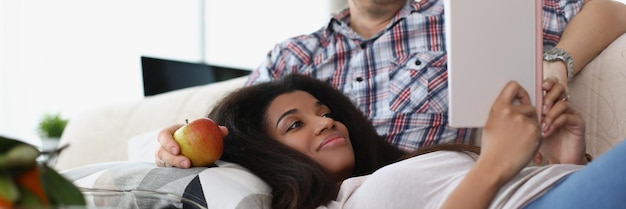 Middle aged man and young latin woman reading book together good friends meet for fun