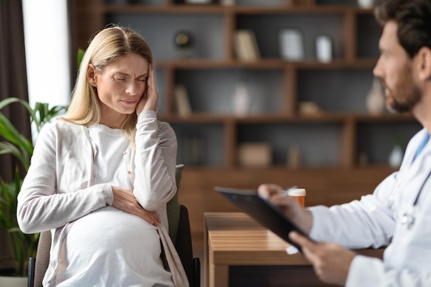 Middle Aged Sick Pregnant Woman Suffering Headache Having Check Up With Doctor