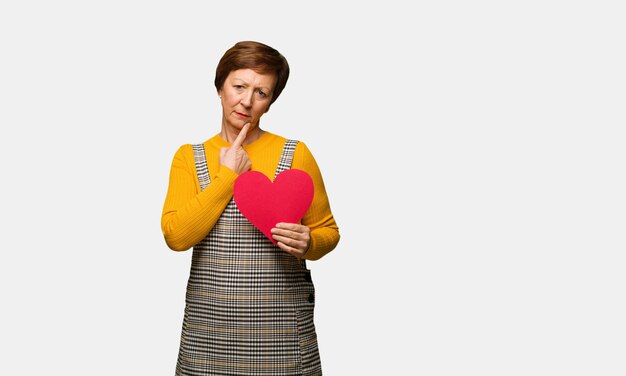 Middle aged woman celebrating valentines day doubting and confused