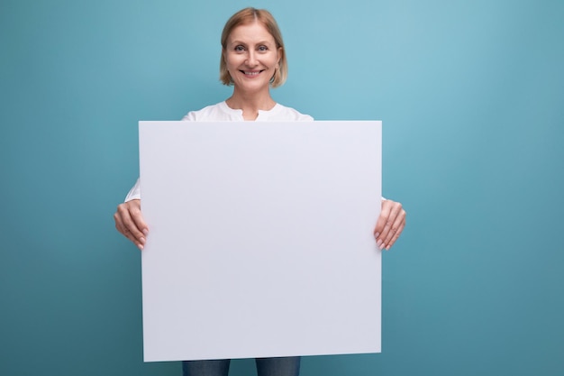 Middle aged woman holding blank white paper for news with mocup