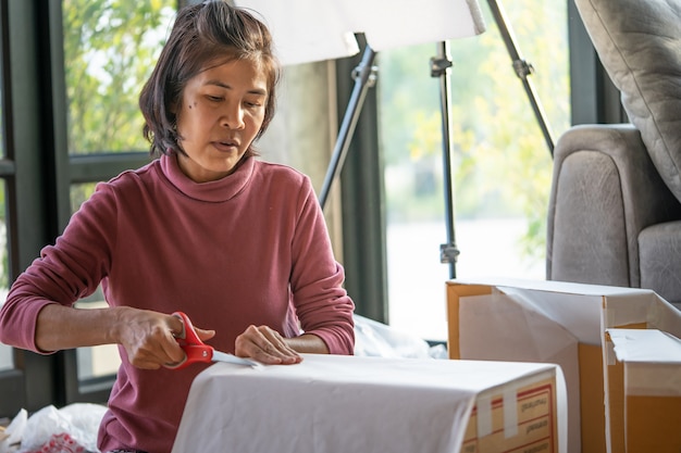 Middle-aged woman is packing products to deliver to customers online