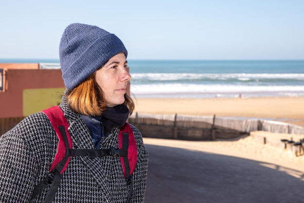 Middle aged woman walking outdoor in winter day in sea beach coast