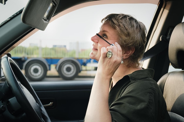 Middle aged woman with short hair driving a car tint eyelashes with mascara