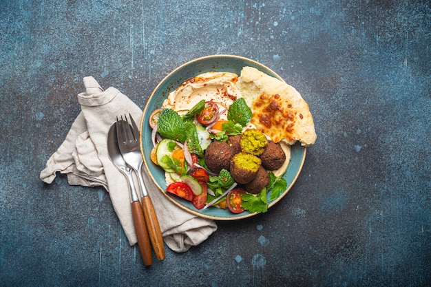 Middle Eastern Arab meal with fried falafel hummus vegetables salad pita bread