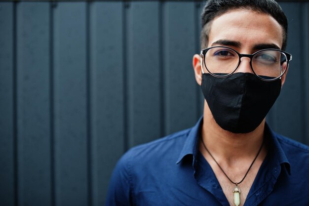 Middle eastern entrepreneur wear black face mask and eyeglasses. New normal life after coronavirus pandemia.