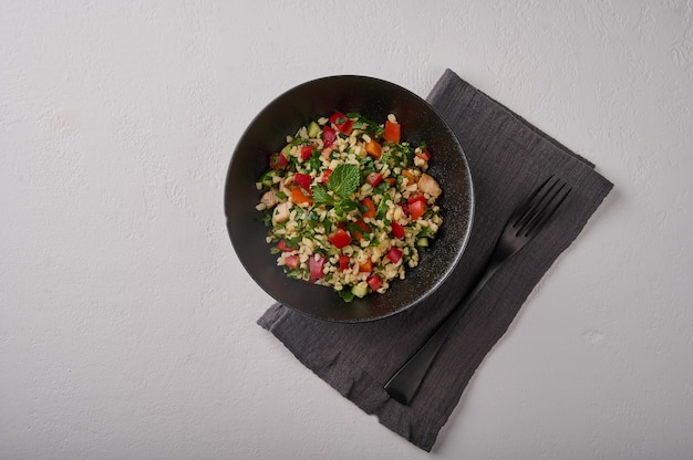 Middle eastern traditional salad tabbouleh made of bulgur or couscous poultry meat parsley mint in