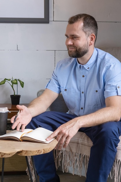 A middleaged Arab man in a business suit talking at a cafe table Smiling businessman writing notes in personal diary