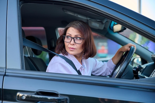 Middleaged beautiful woman driver driving a car