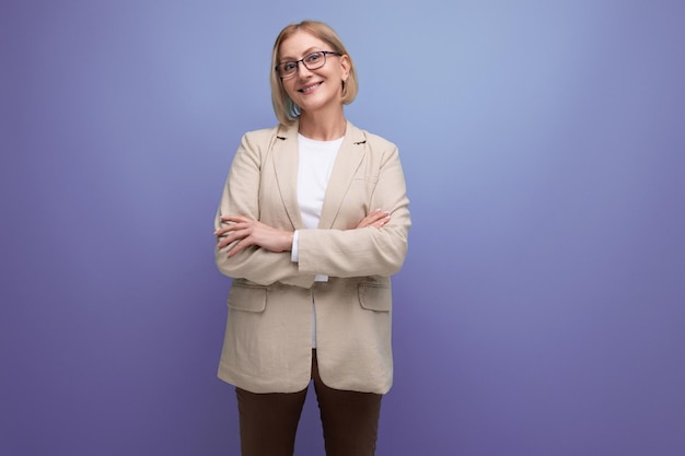 Middleaged business woman smiling in a jacket on a bright studio background with copy space