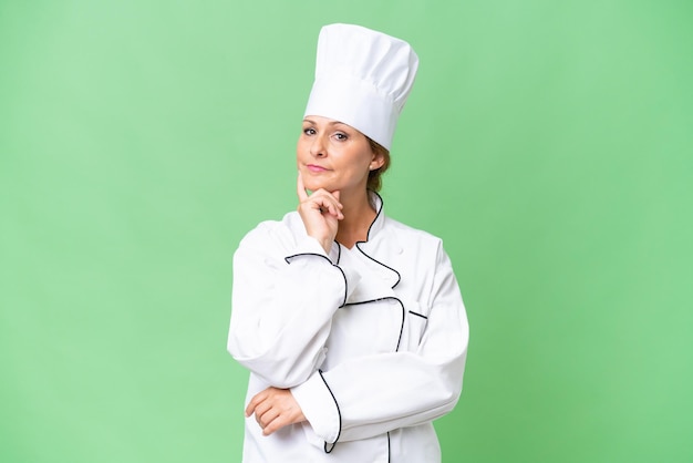 Middleaged chef woman over isolated background smiling