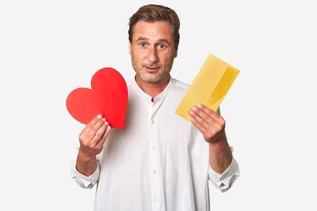 Middleaged gentleman holds a paper heart and love letter radiating sentiment