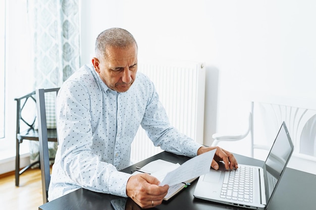 Middleaged man writes notes in notebook