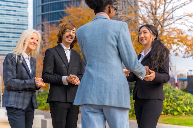 Middleaged multiethnic businessmen and businesswomen shaking hands in good working environment