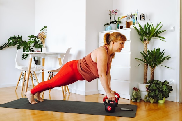 Middleaged woman does yoga in bright spacious room with house plants