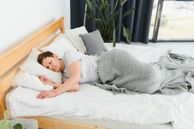 Middleaged woman sleeping in bed at home